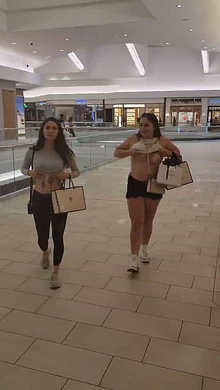 Two girls flashing their boobs in public'