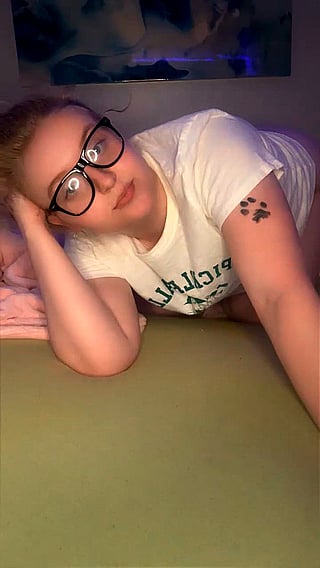 Backside of a girl wearing glasses and a white shirt.'