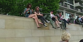 Sitting on a wall like a statue'